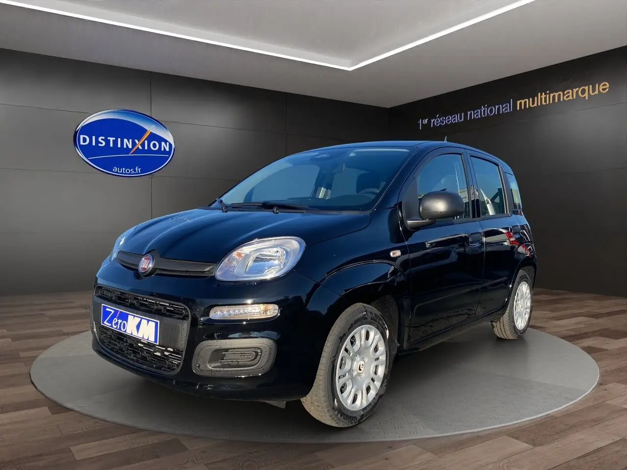 Vue 3/4 avant droite de la Fiat Panda noire 2025 avec jantes acier et feux LED, en showroom.