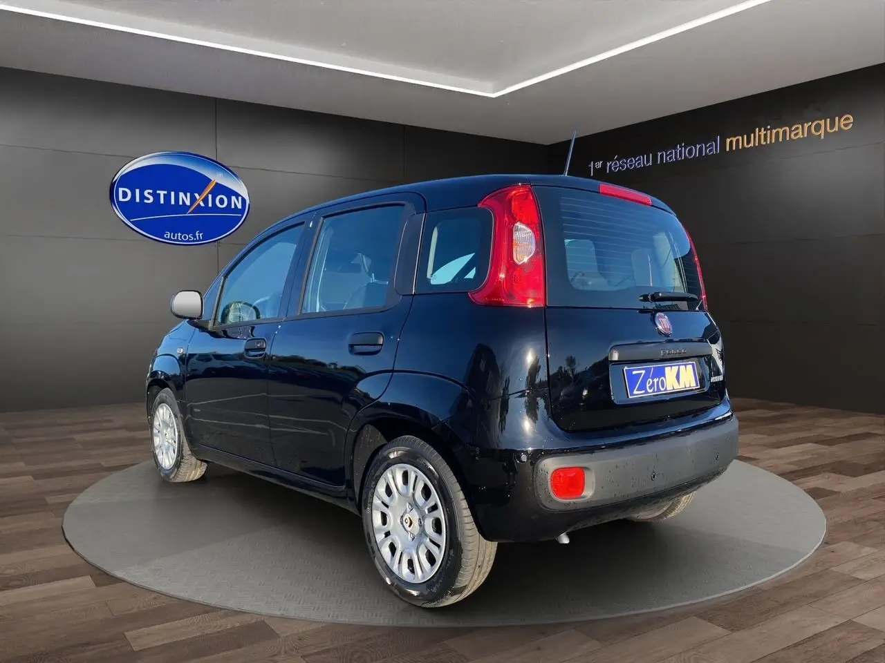 Vue 3/4 arrière droite d'une Fiat Panda noire 2025 avec cinq portes, en présentation showroom.