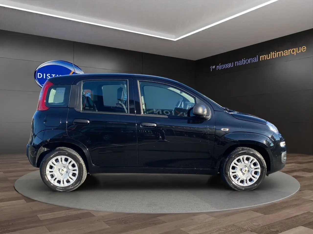 Profil côté gauche d'une FIAT Panda noire 2025 5 portes, avec jantes argentées et rétroviseurs gris métallisé.