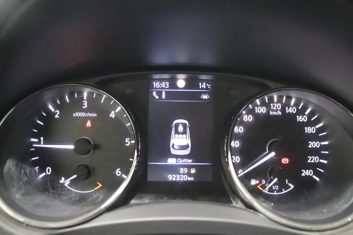 Vue rapprochée du tableau de bord du Nissan X-Trail 1.7 D gris, affichant 92 320 km et jauge carburant presque vide.