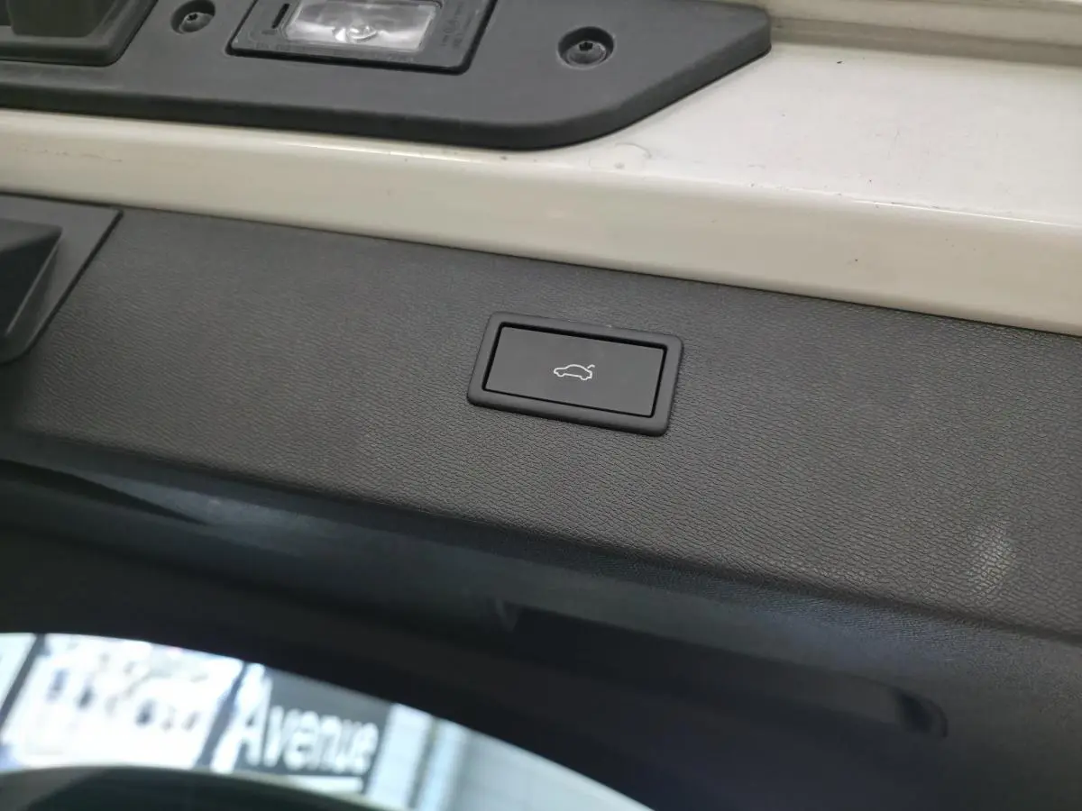 Bouton d'ouverture électrique du hayon sur la partie intérieure du coffre d'un CUPRA Formentor blanc.