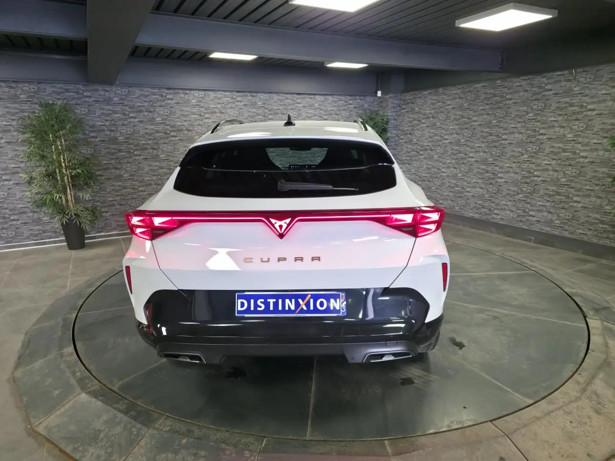 Vue arrière d'une CUPRA Formentor blanche 2025 avec feux arrière en bandeau lumineux Tri-LED et diffuseur noir contrastant.