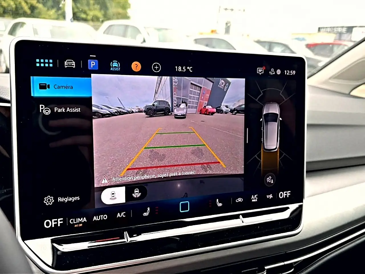 Écran tactile intérieur de la Volkswagen Golf noir 2026 montrant la caméra de recul et l'assistance au stationnement.