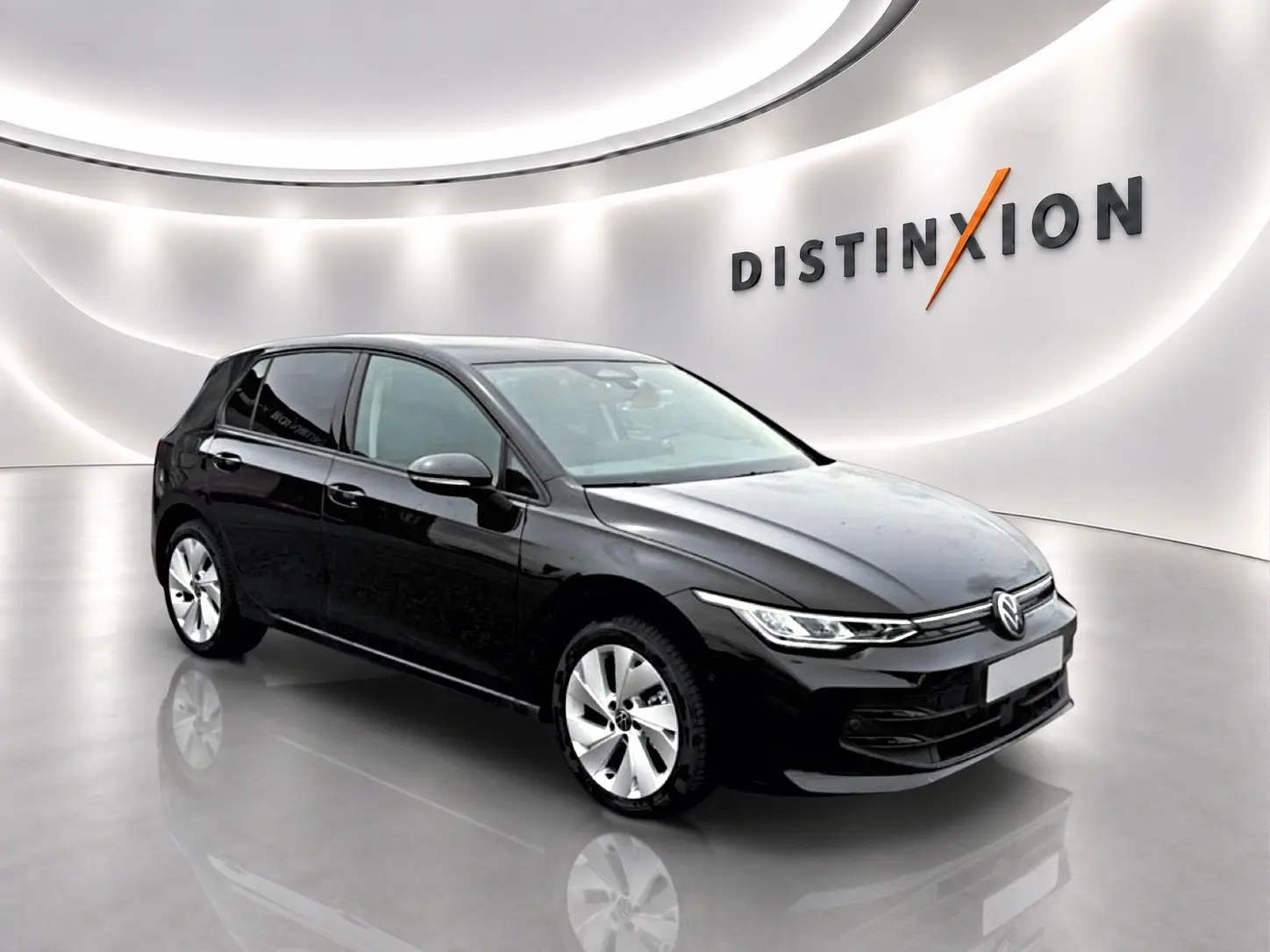 Volkswagen Golf noire vue en 3/4 avant droit dans un showroom lumineux avec jantes alu 17 pouces.