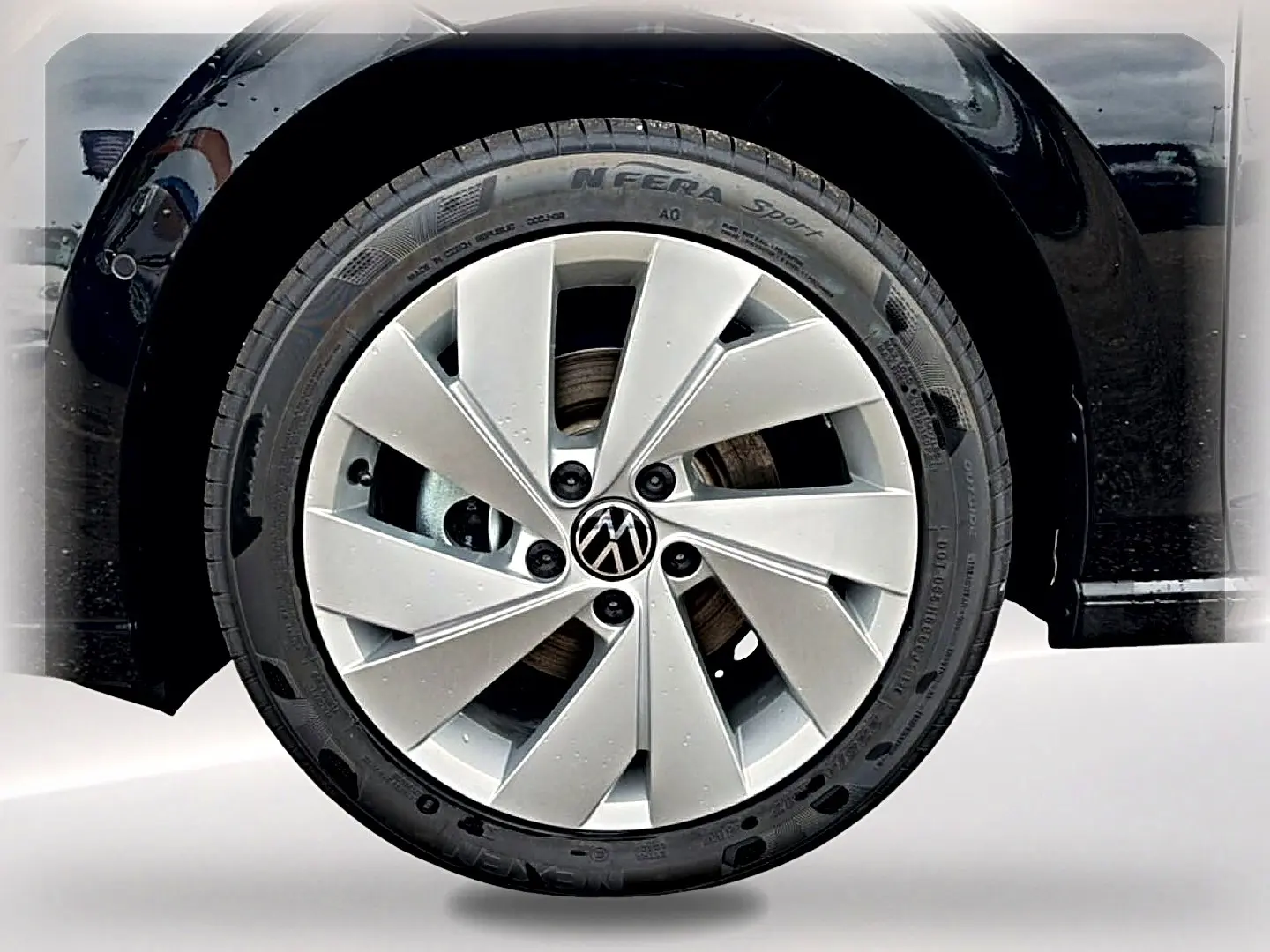 Gros plan sur la roue avant droite noire d'une Volkswagen Golf 2026 avec jante alu 17 pouces argentée.