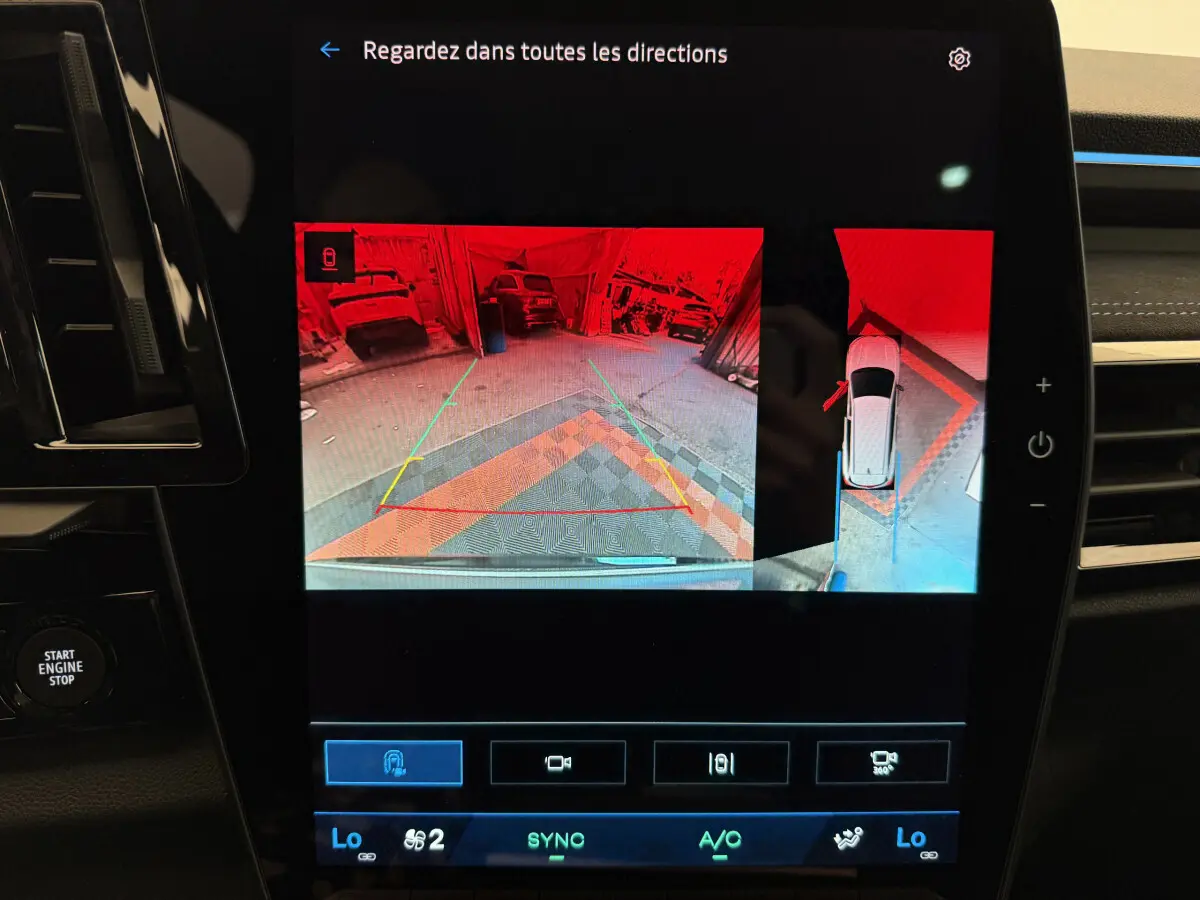 Écran tactile central du Renault Espace gris foncé 2025 montrant la caméra de recul et l'aide au stationnement en vue arrière.