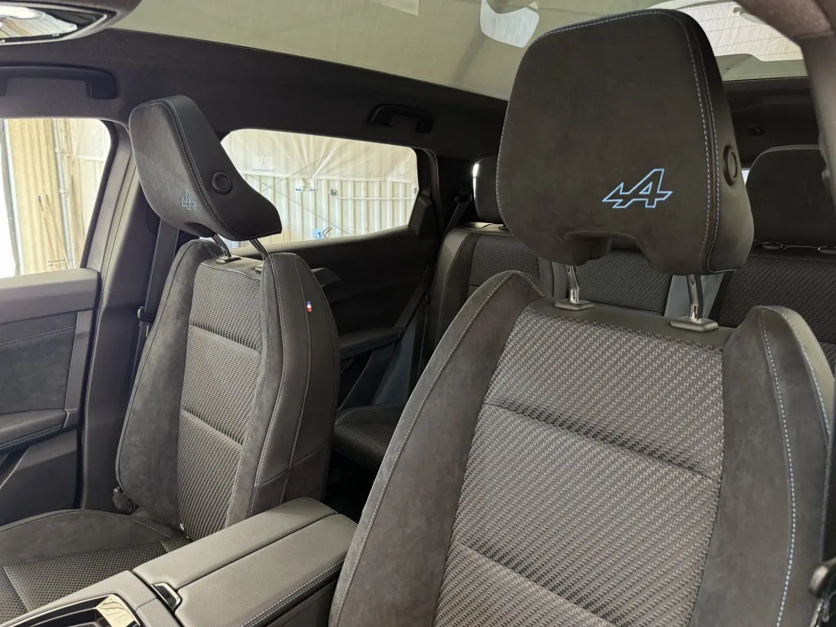 Intérieur du Renault Espace esprit Alpine 2025, vue côté droit sur sièges en suède gris foncé avec logo Alpine brodé.