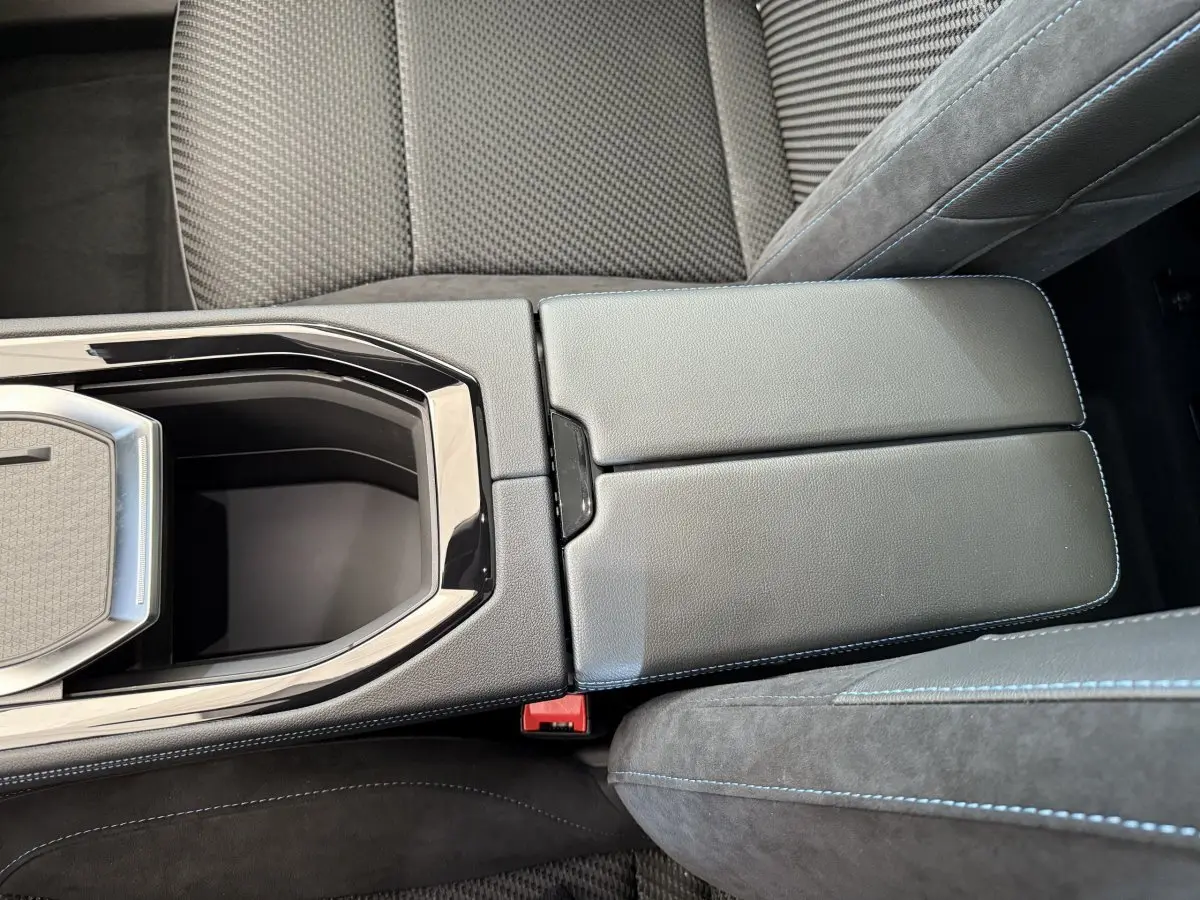 Gros plan sur la console centrale en cuir noir avec surpiqûres bleues et accoudoir du Renault Espace esprit Alpine 2025.