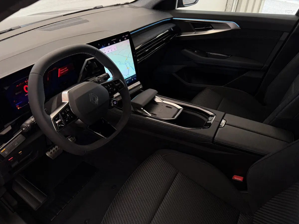 Intérieur noir du Renault Espace 2025 esprit Alpine, vue côté conducteur avec écran tactile central et volant cuir-suède.