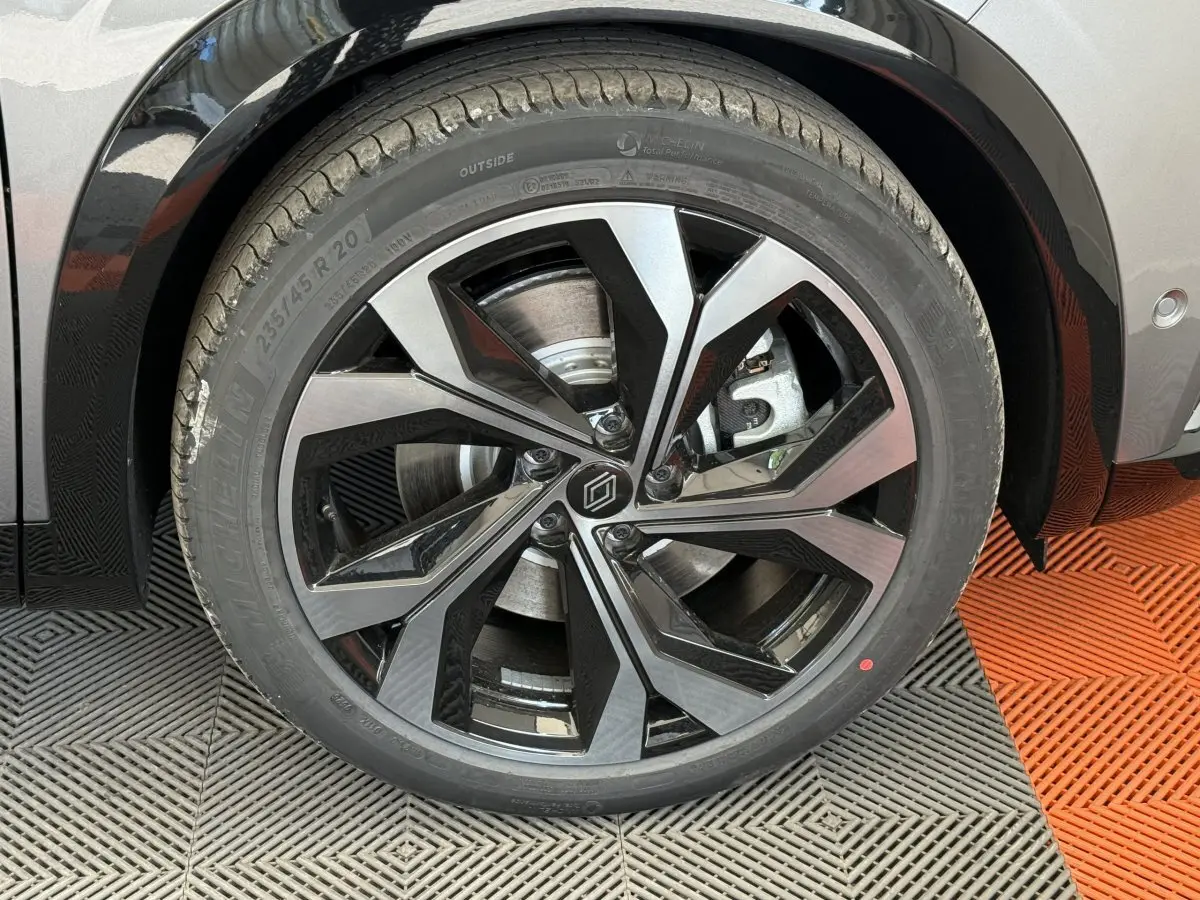 Gros plan sur la roue avant droite du Renault Espace gris foncé, mettant en valeur la jante alliage noire et argentée au design moderne.