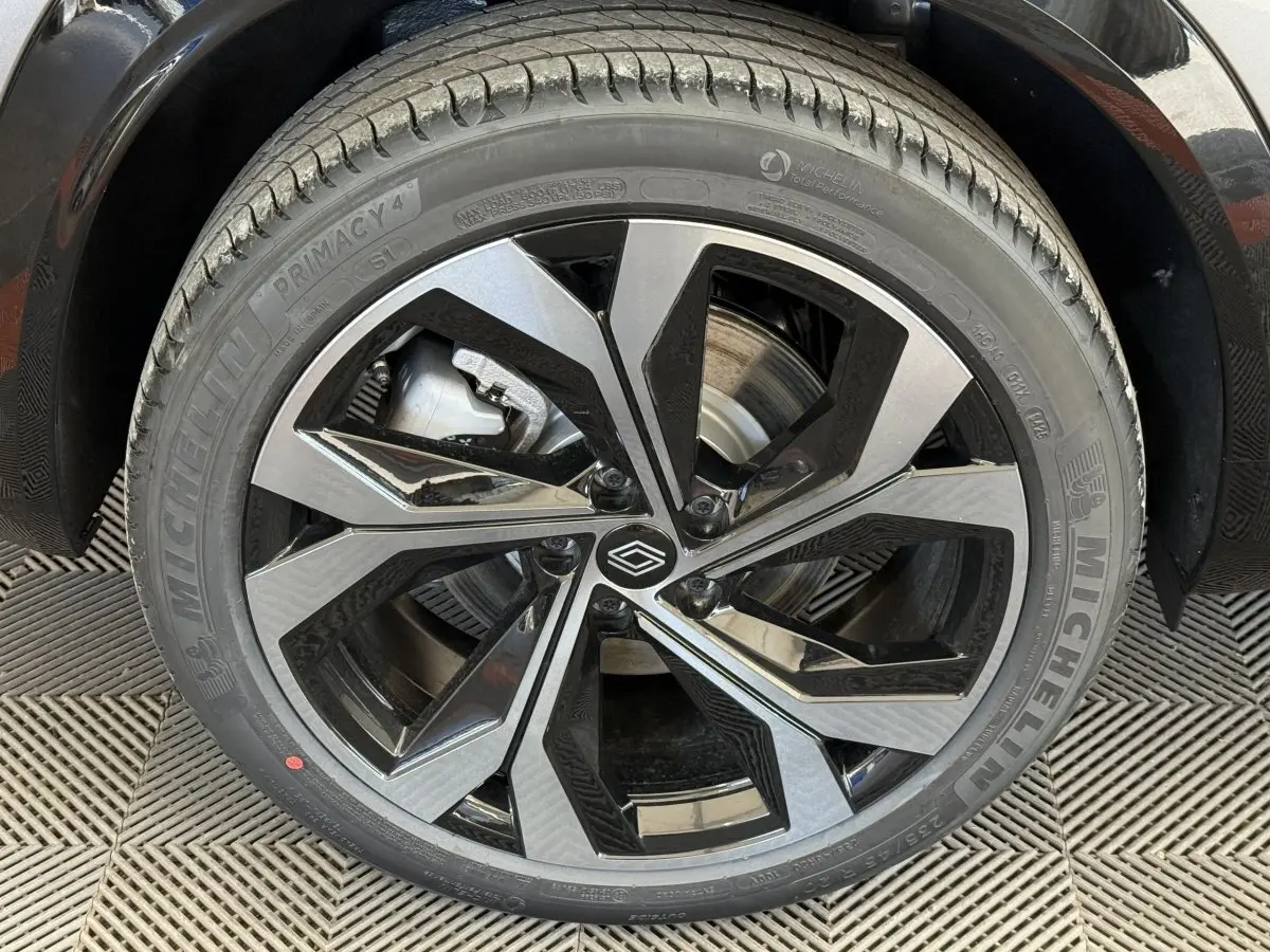 Gros plan sur la jante alliage bicolore et pneu Michelin du côté arrière droit d'un Renault Espace gris foncé 2025 esprit Alpine.