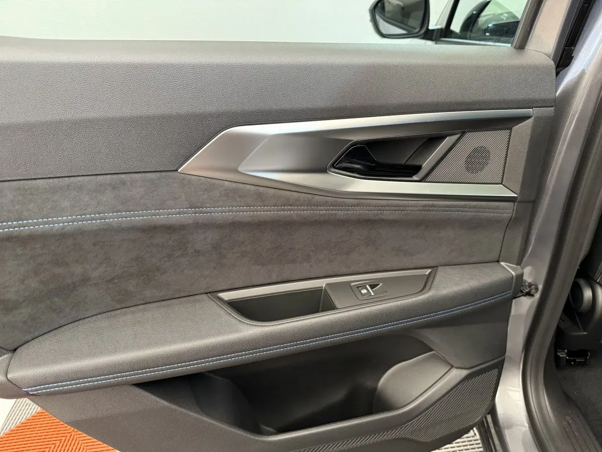 Détail de la porte intérieure côté gauche du Renault Espace esprit Alpine 7PL gris foncé avec surpiqûres bleues.