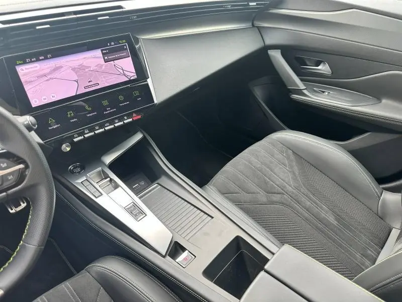 Intérieur avant droit de la Peugeot 308 SW 2023 avec siège noir, console centrale moderne et écran tactile de navigation.