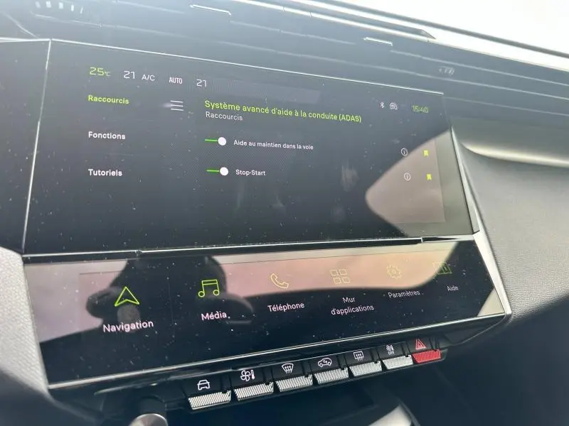 Écran tactile central du tableau de bord de la Peugeot 308 SW 2023 affichant les aides à la conduite et la climatisation.