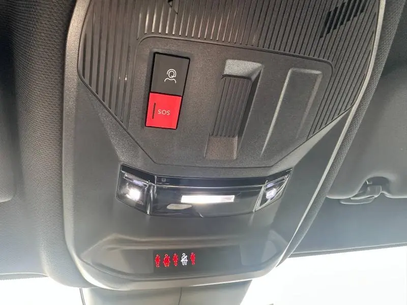Vue en gros plan du plafonnier noir avec bouton SOS rouge et éclairage intérieur de la Peugeot 308 SW 2023.