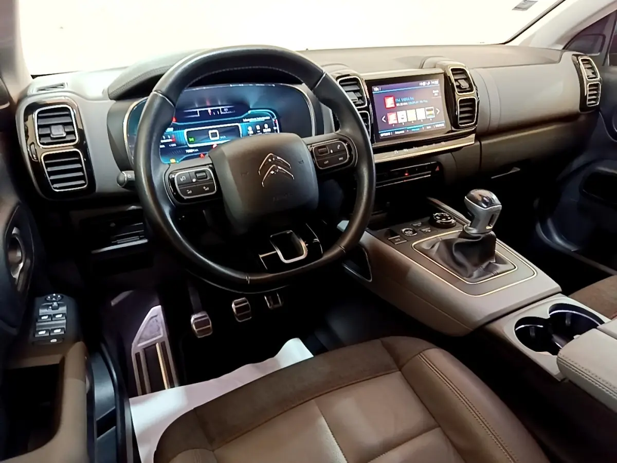 Intérieur de Citroën C5 Aircross gris foncé, vue côté conducteur sur volant cuir et console centrale avec boîte manuelle.