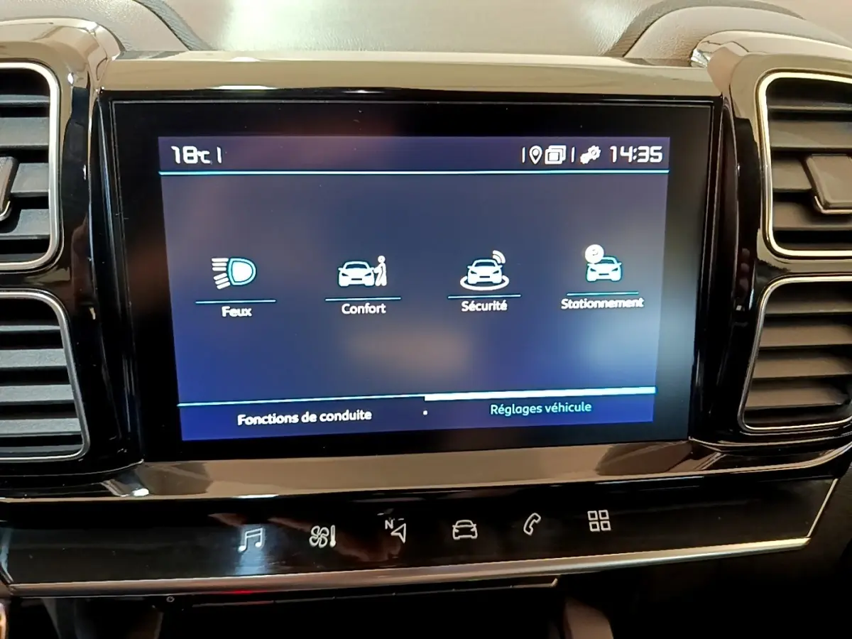 Écran tactile central affichant les réglages du véhicule dans un Citroën C5 Aircross gris foncé, vue intérieure frontale.