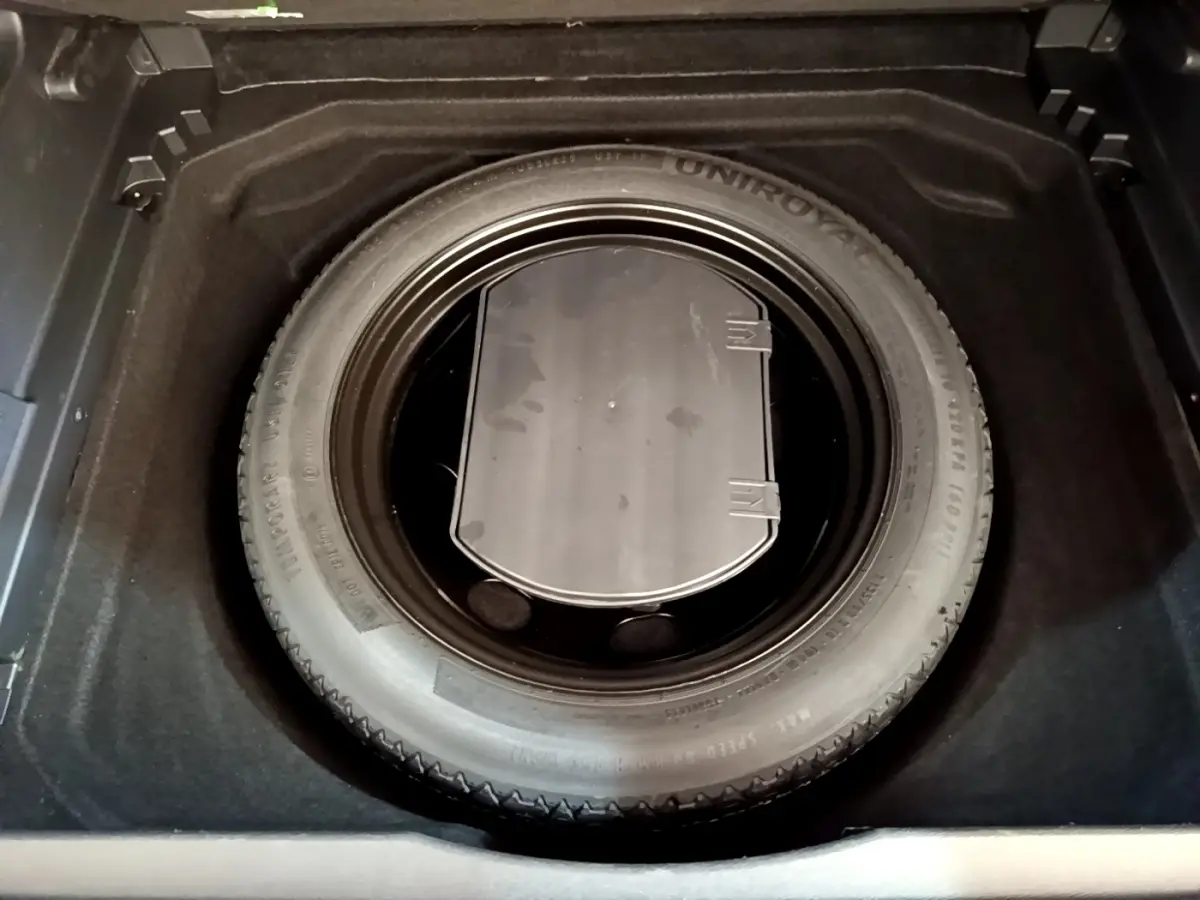 Vue plongeante sur la roue de secours dans le coffre du Citroën C5 Aircross gris foncé 2020.