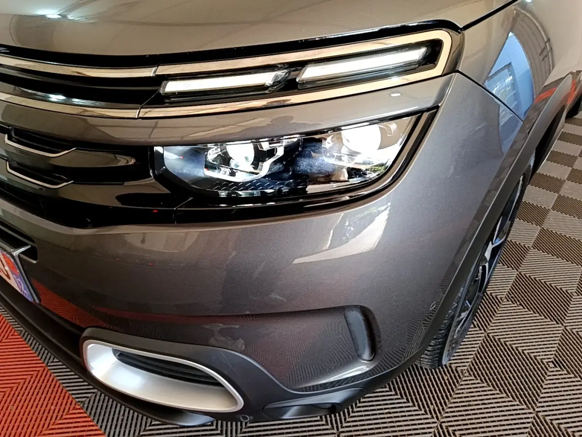 Gros plan sur l’avant droit gris foncé du Citroën C5 Aircross 2020, mettant en valeur le phare LED et la calandre chromée.