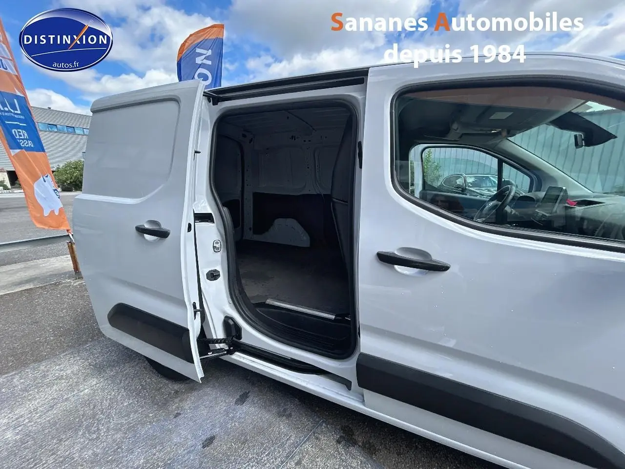 Vue latérale droite du Toyota Proace City blanc 2023 avec porte coulissante ouverte montrant l'espace de chargement vide.