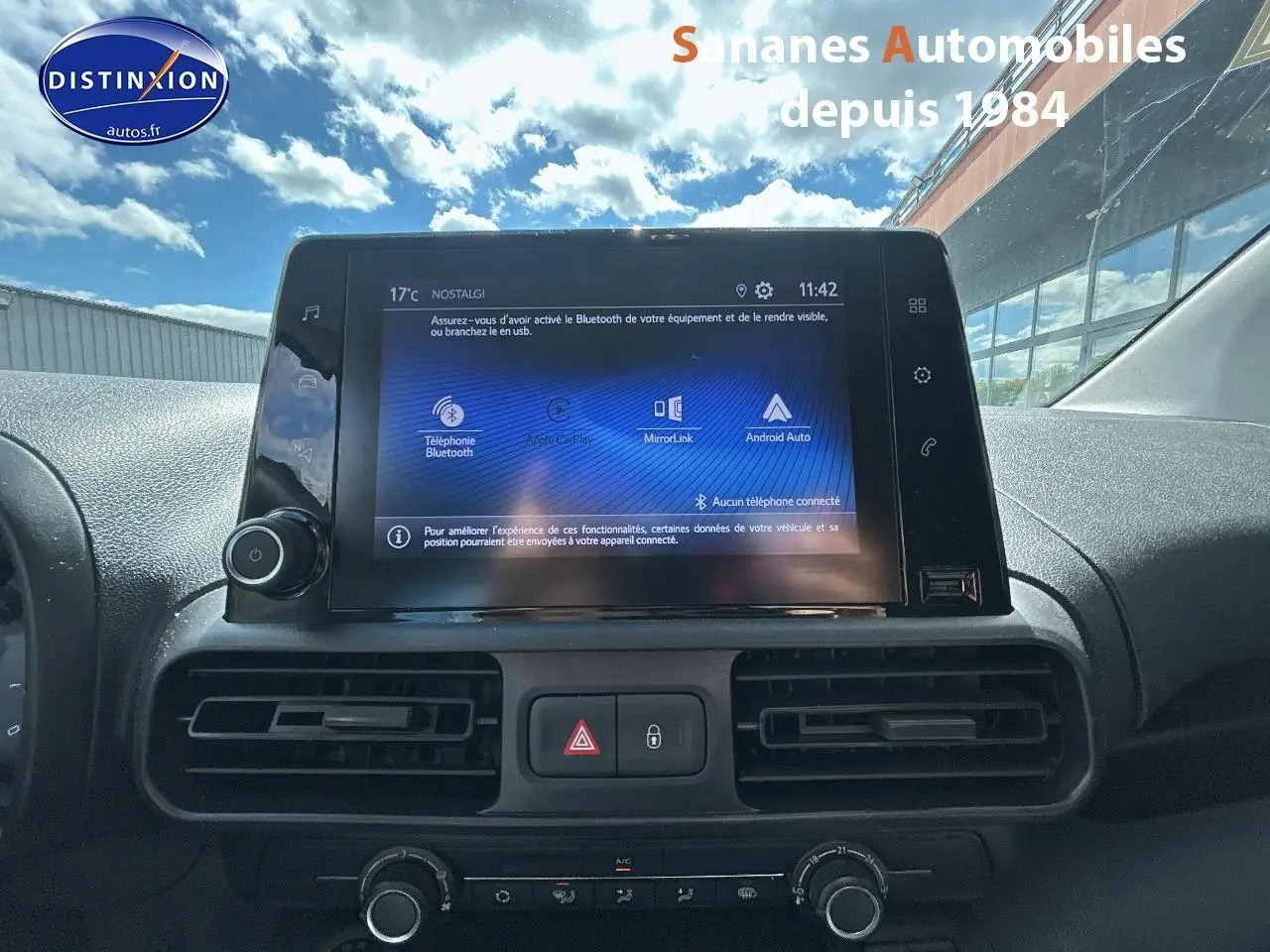 Vue rapprochée de l’écran tactile central du Toyota Proace City 2023 avec commandes de climatisation et tableau de bord noir.