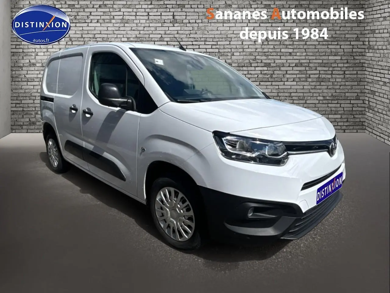 Toyota Proace City blanc vue 3/4 avant droit avec coques de rétroviseurs noires et porte latérale tôlée.