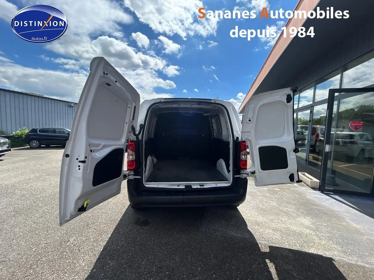 Vue arrière d'un Toyota Proace City blanc 2023 avec portes arrière ouvertes montrant l'espace de chargement vide.