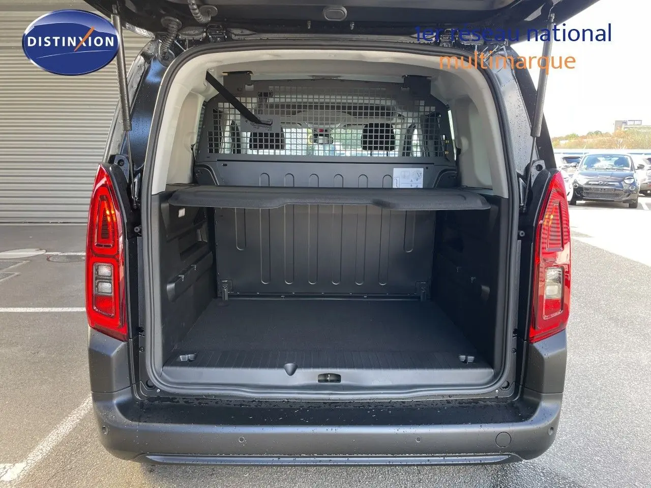 Vue arrière ouverte du Citroën Berlingo MPV M noir Perla Nera, montrant le coffre spacieux avec séparation métallique.