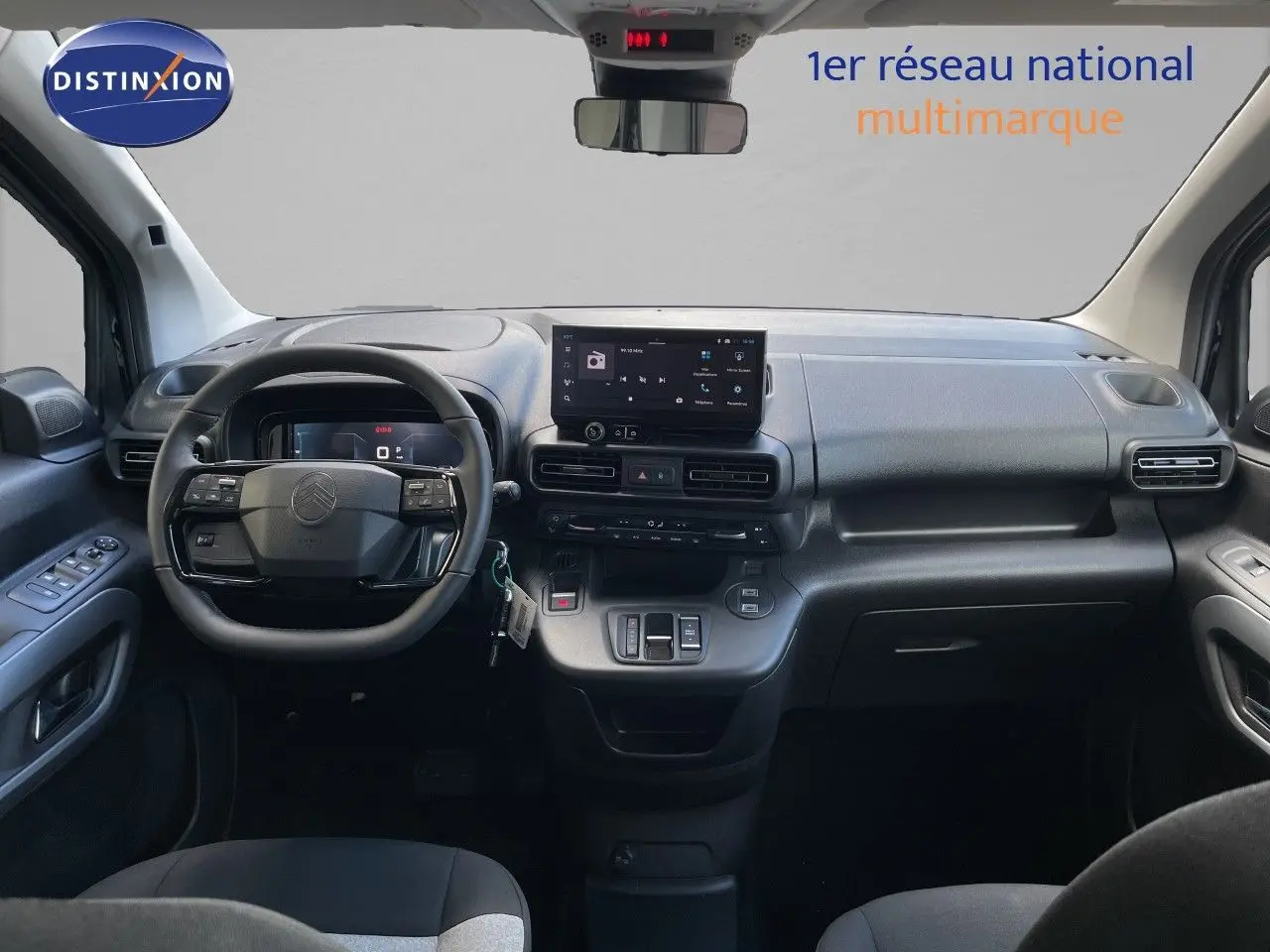Vue intérieure frontale du tableau de bord noir du Citroën Berlingo 2026 avec écran tactile et volant multifonction.