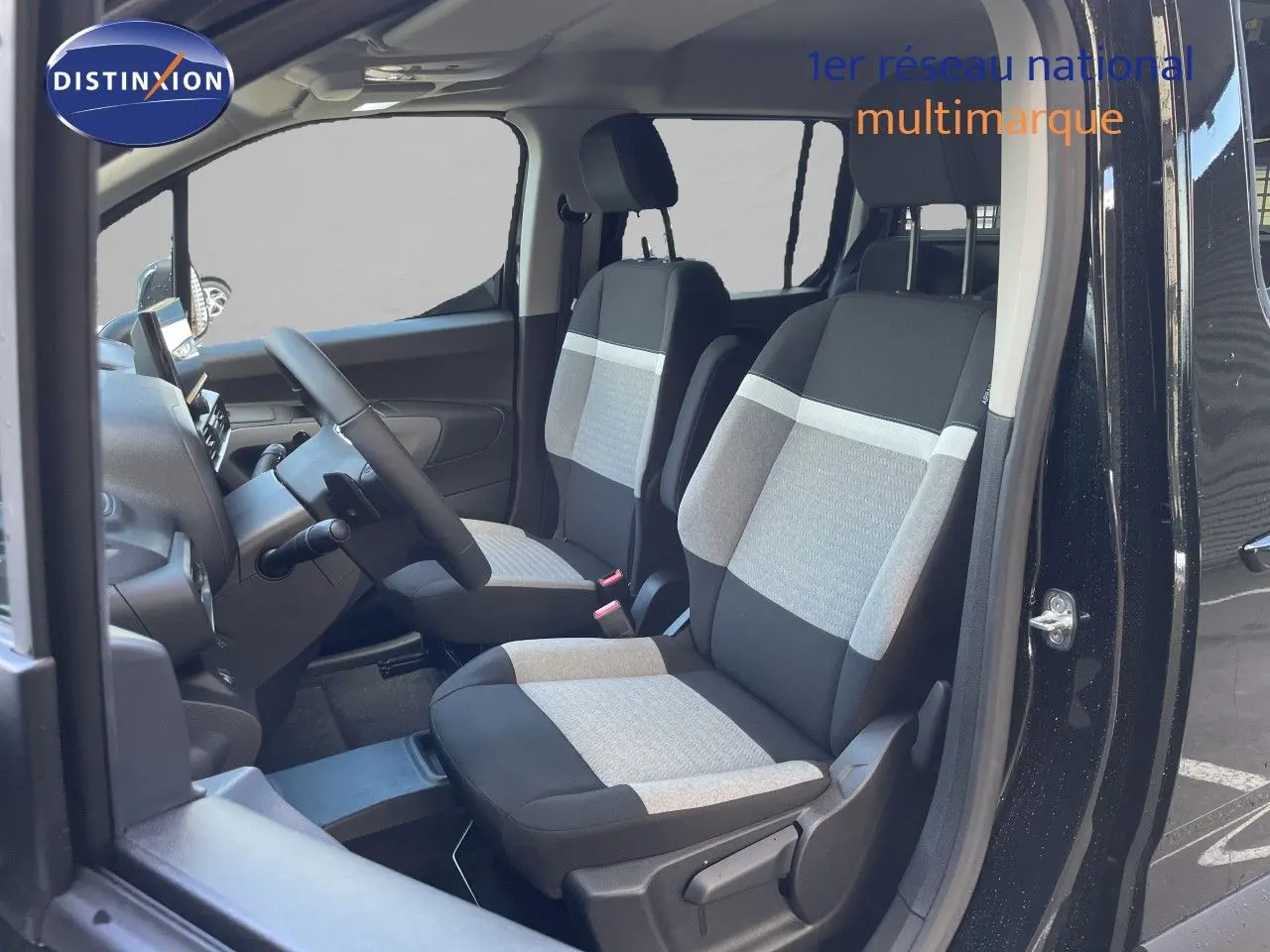 Vue intérieure côté gauche du Citroën Berlingo noir Perla Nera, montrant les sièges avant en tissu bicolore gris et noir.