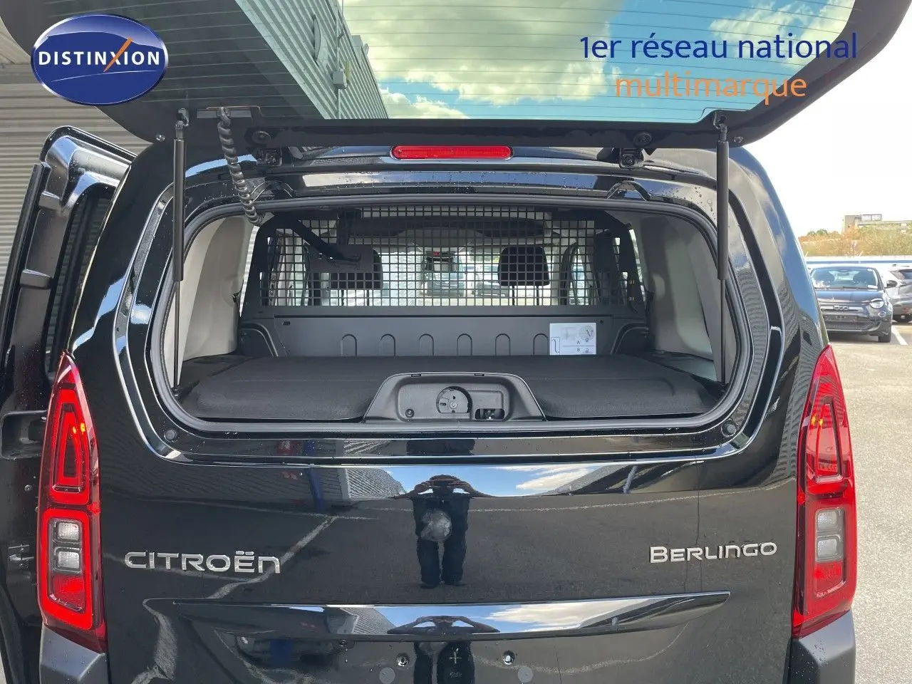 Vue arrière du Citroën Berlingo noir Perla Nera avec hayon ouvert, montrant le coffre et la grille de séparation intérieure.