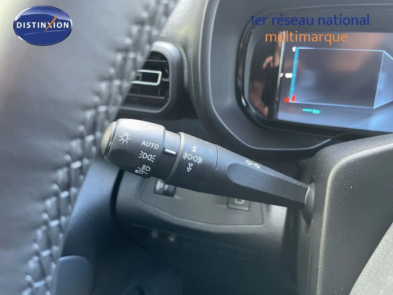 Gros plan sur la commande des feux et clignotants du Citroën Berlingo 2026, intérieur noir, tableau de bord partiellement visible.