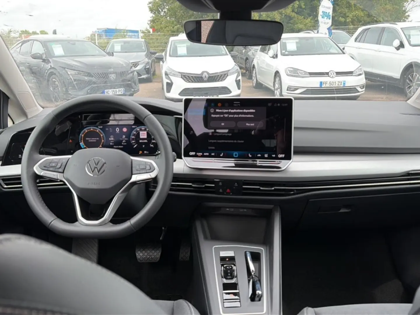 Vue intérieure avant de la Volkswagen Golf noire 2026, avec tableau de bord digital et grand écran central tactile.