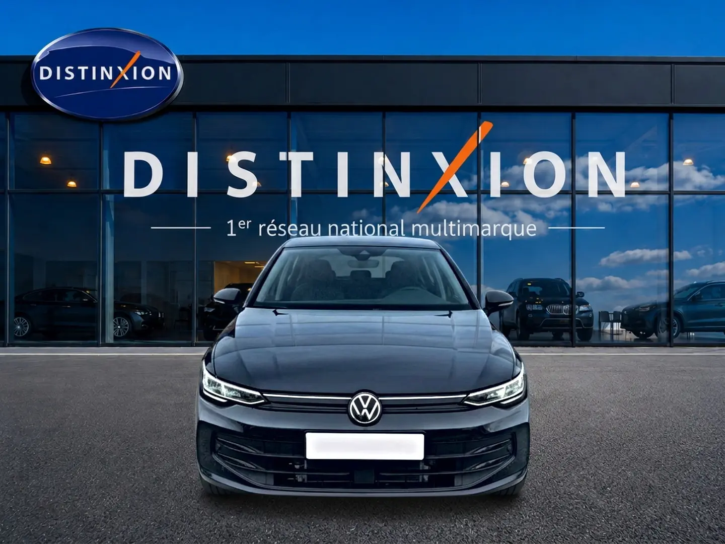 Vue frontale d'une Volkswagen Golf noire 2026 garée devant une vitrine avec logo Distinxion.