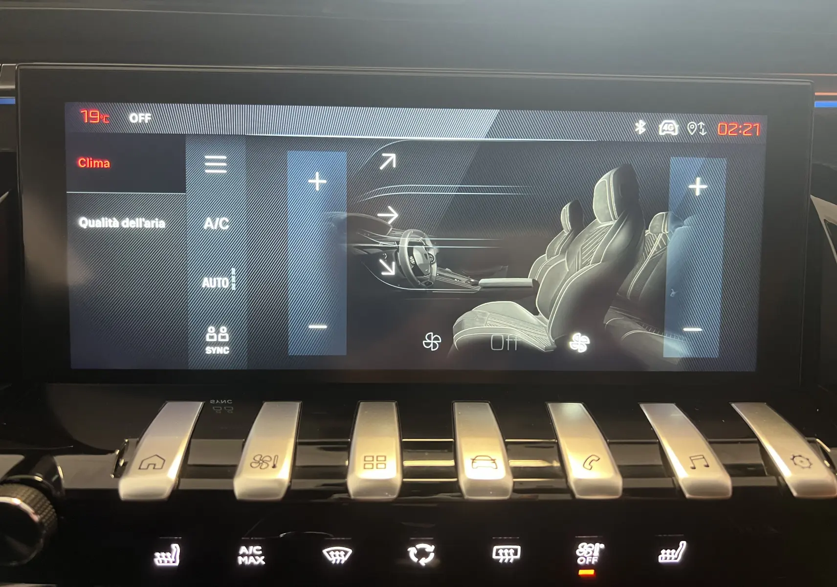 Écran tactile du système de climatisation du Peugeot 508 SW 2024 montrant les sièges avant en gris et les commandes en chrome.