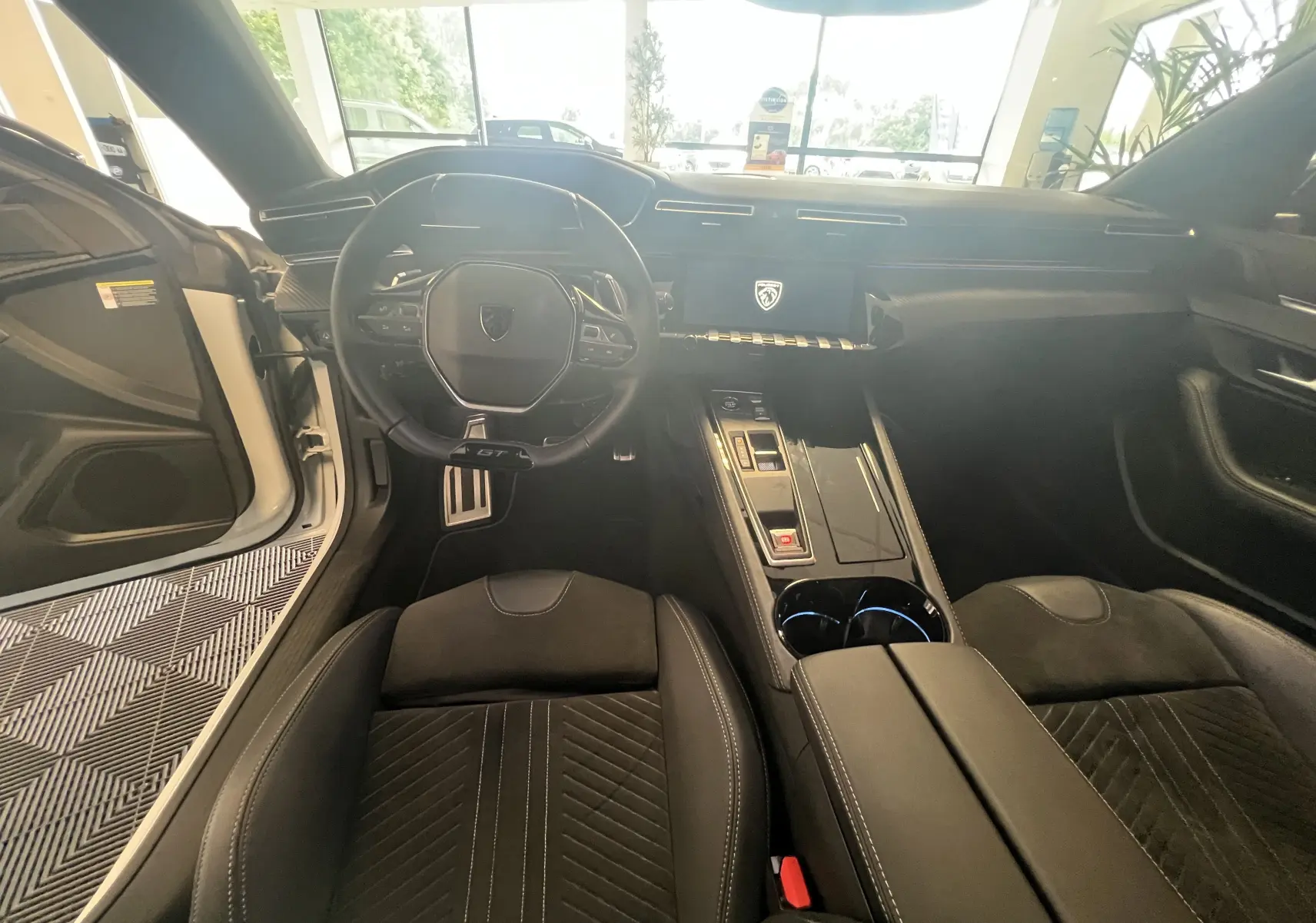 Intérieur noir de la Peugeot 508 SW 1.5 HDI GT 2024, vue depuis le siège conducteur sur le volant GT et la console centrale moderne.
