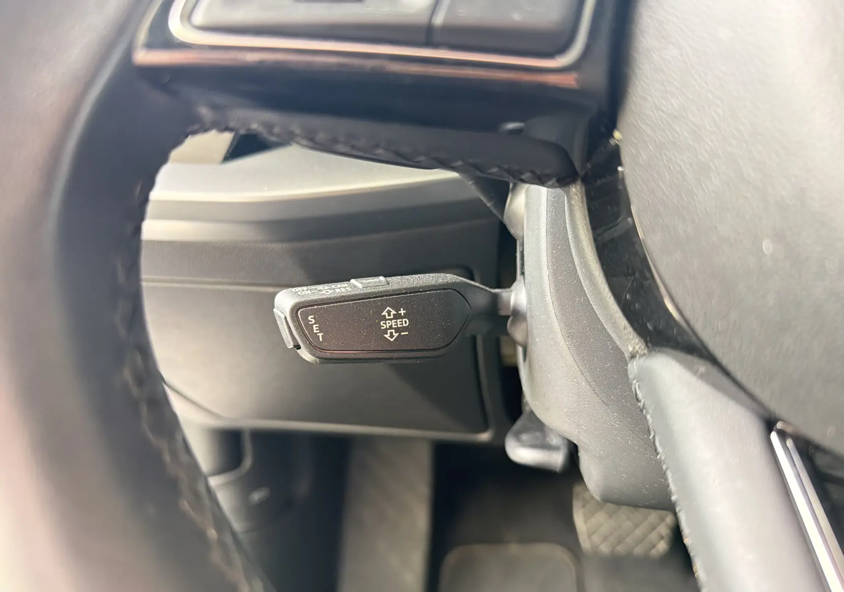 Gros plan sur le levier de régulateur de vitesse situé derrière le volant d'une Audi A3 Sportback gris Manhattan.