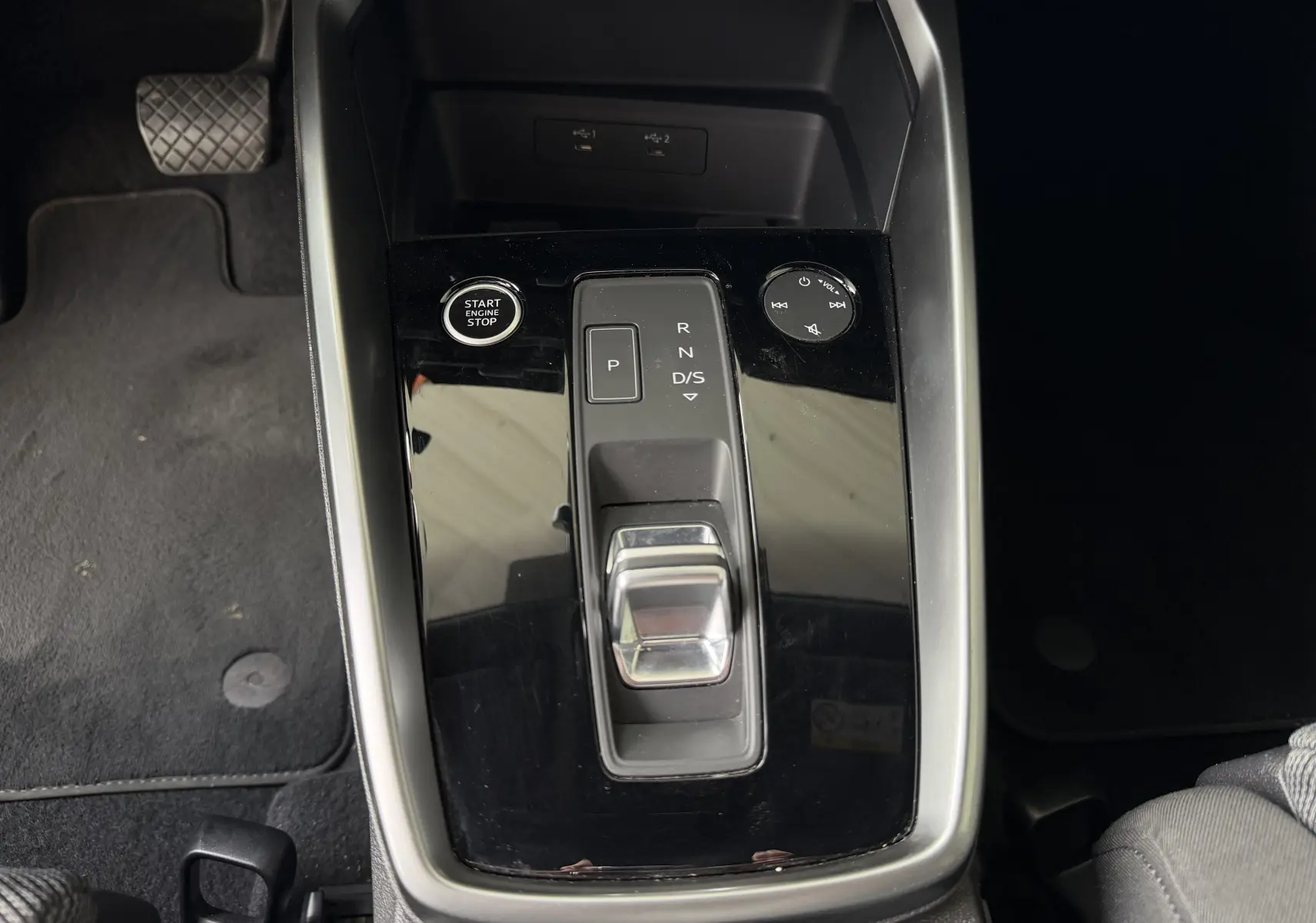 Vue rapprochée de la console centrale noire brillante de l'Audi A3 Sportback 35 TDI avec sélecteur de boîte auto et bouton start/stop.