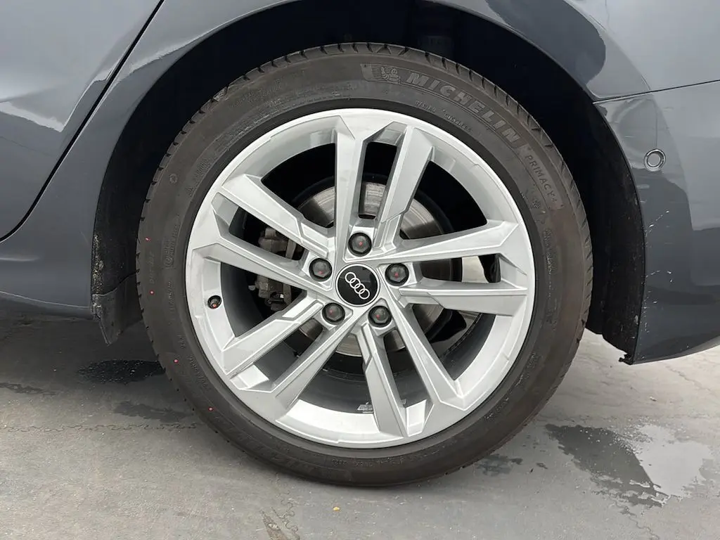 Gros plan sur la roue arrière droite d'une Audi A3 Sportback 2021 gris Manhattan avec jante alliage à cinq branches doubles.