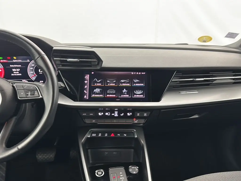 Vue intérieure de l'Audi A3 Sportback 2021, tableau de bord avec écran tactile central et volant partiel à gauche.