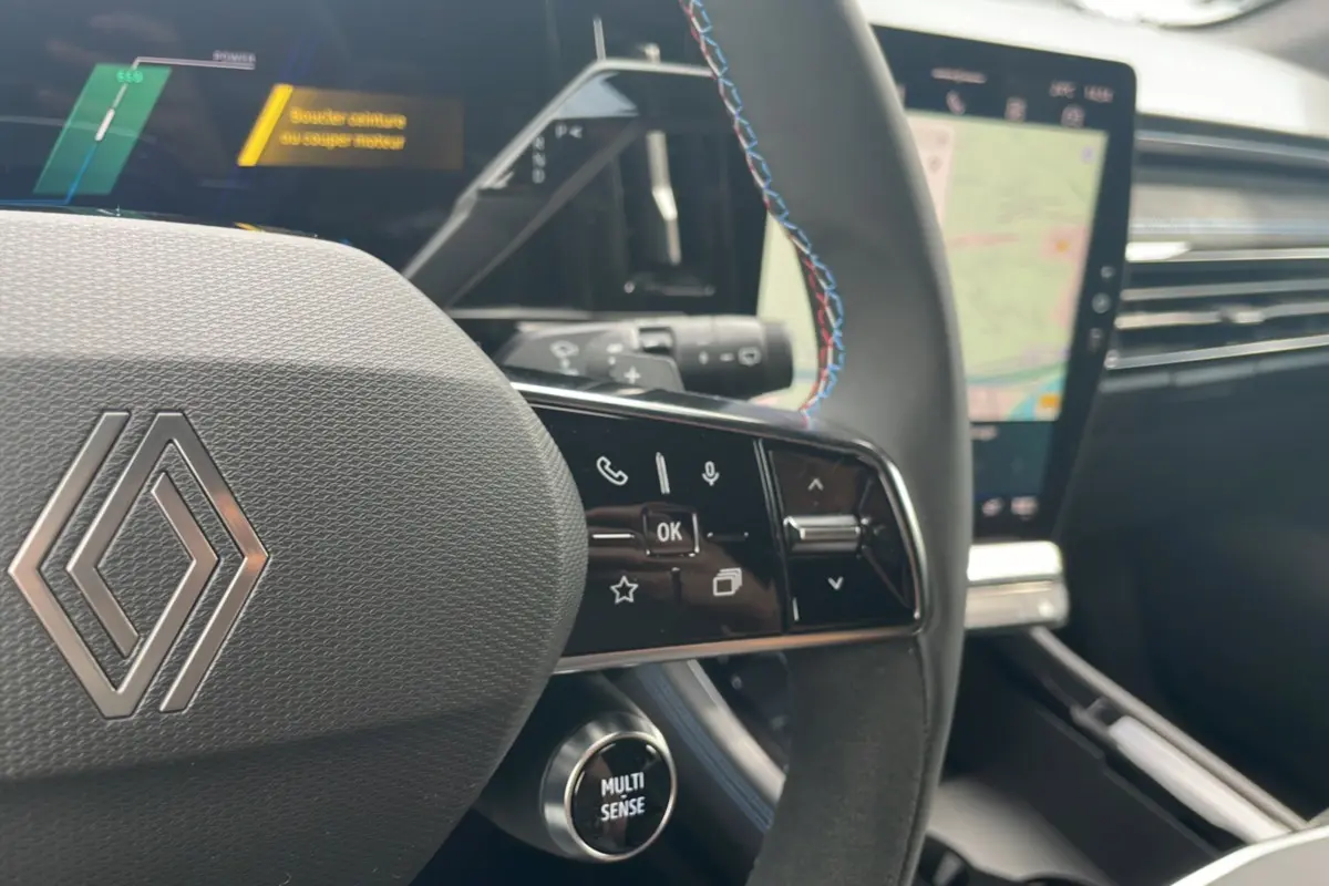 Gros plan sur le volant cuir multifonctions avec surpiqûres tricolores du Renault Austral New 200 Esprit Alpine.