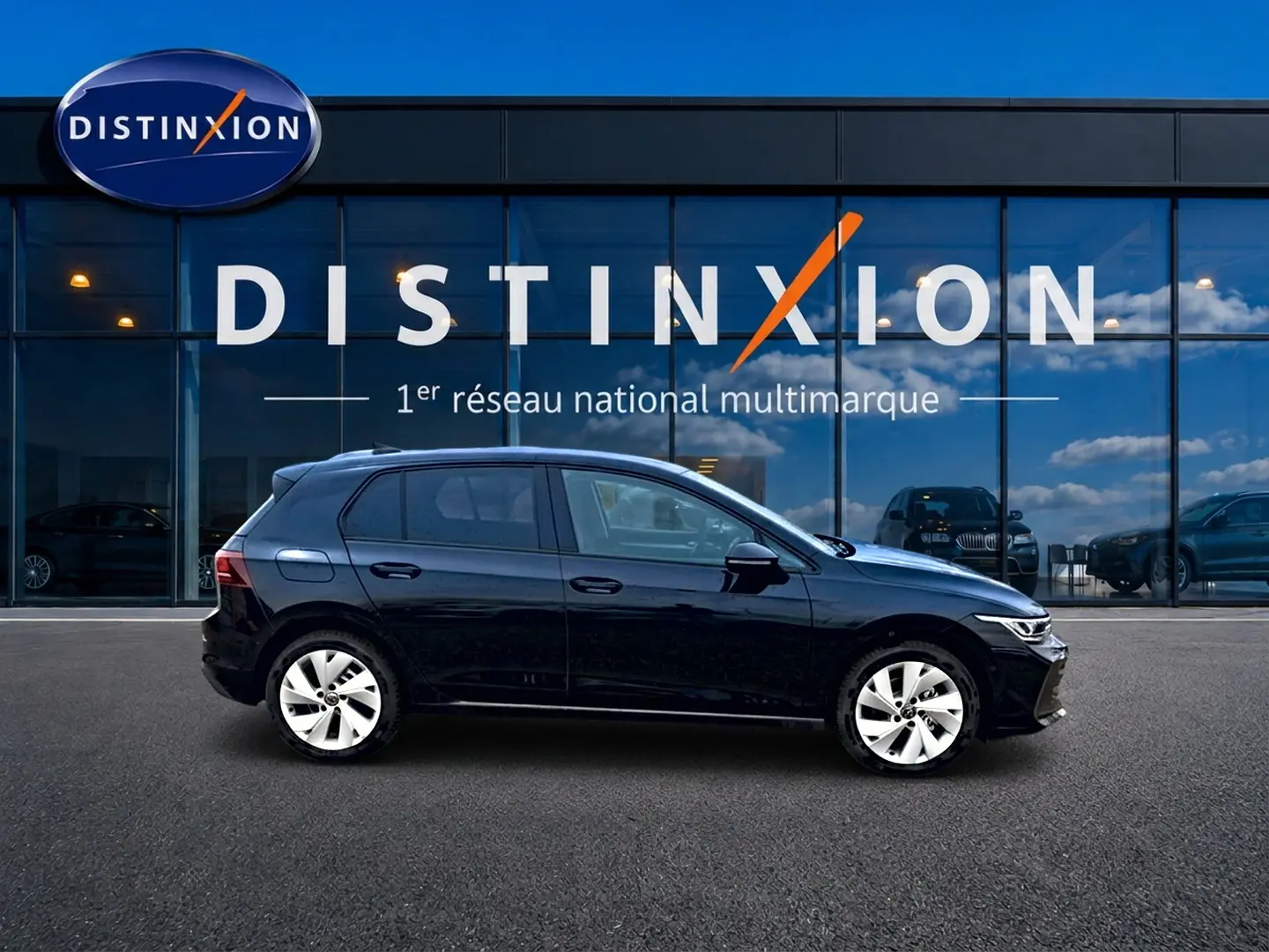 Volkswagen Golf 1.5 ETSI Evo2 noire vue de profil côté gauche devant une vitrine avec logo Distinxion.
