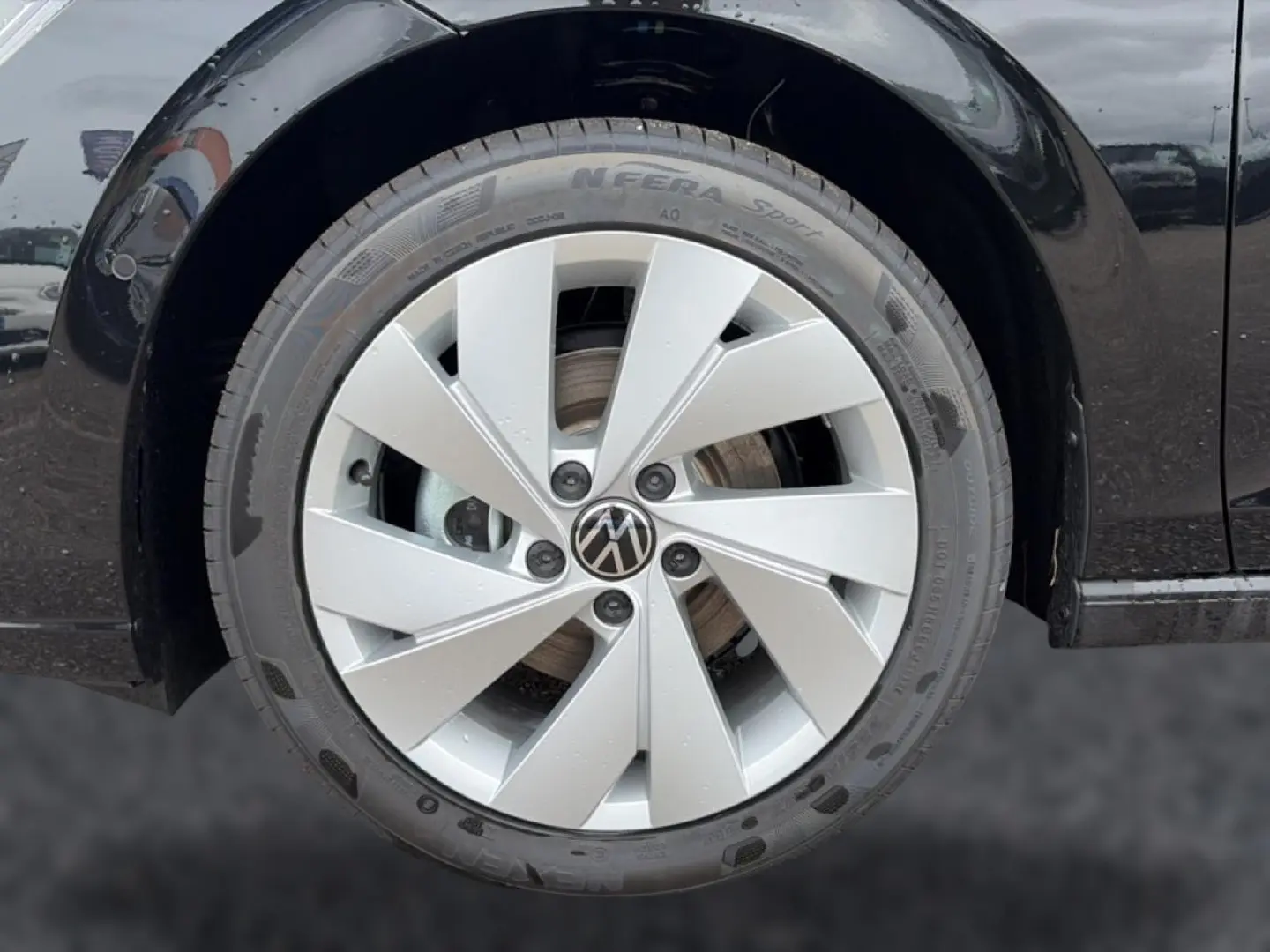 Gros plan sur la jante alu 17 pouces argentée d’une Volkswagen Golf noire, côté arrière droit du véhicule.