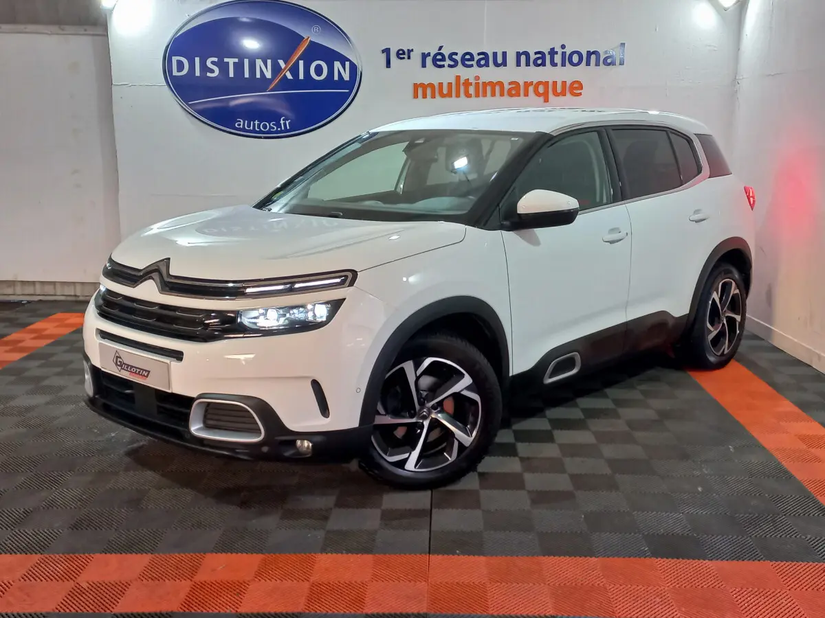 Citroën C5 Aircross blanc en 3/4 avant droit, avec jantes noires et détails noirs contrastants visibles.