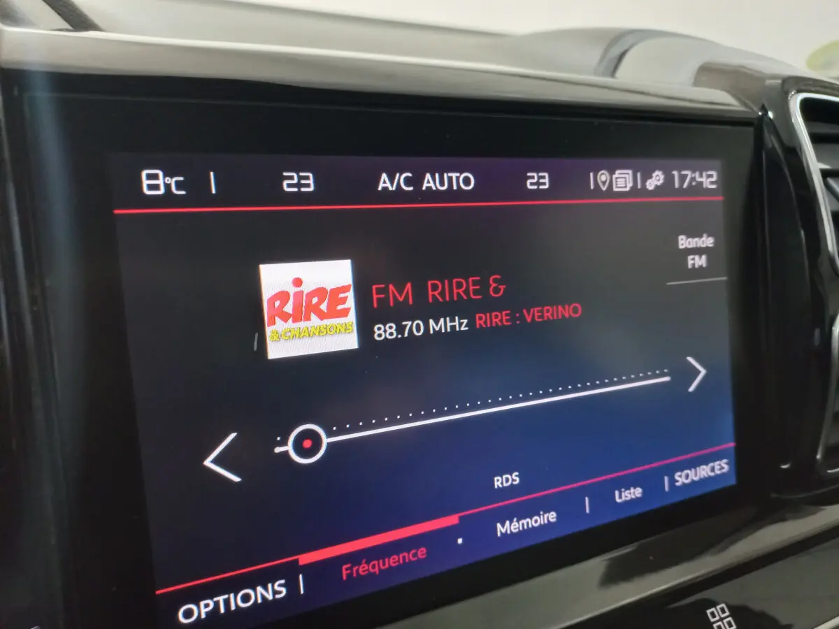 Écran tactile central affichant la radio FM dans l'habitacle du Citroën C5 Aircross blanc, vue rapprochée.