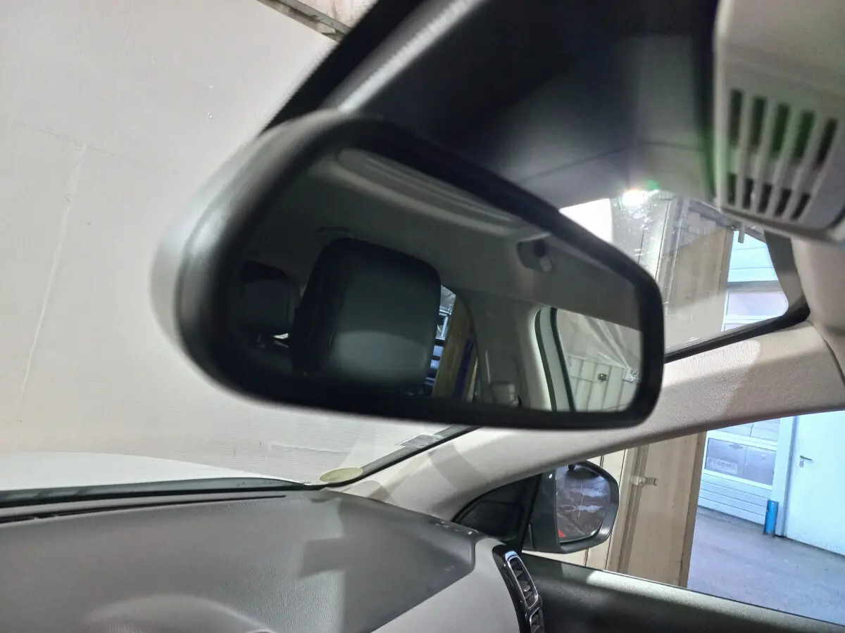 Rétroviseur intérieur montrant l'appui-tête noir côté conducteur du Citroën C5 Aircross blanc, vue depuis l'avant droit.