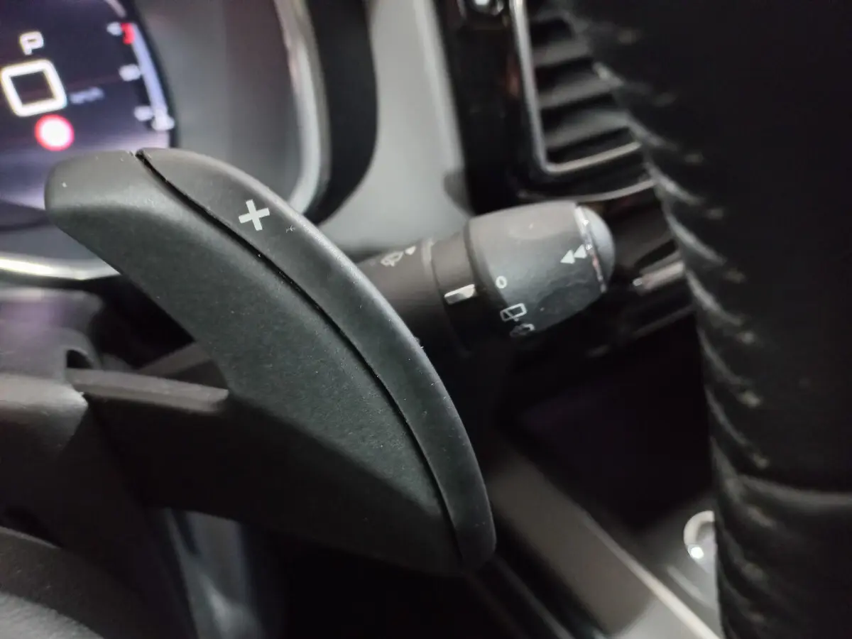 Gros plan sur la palette de changement de vitesse droite noire du volant du Citroën C5 Aircross blanc, version Feel 2020.