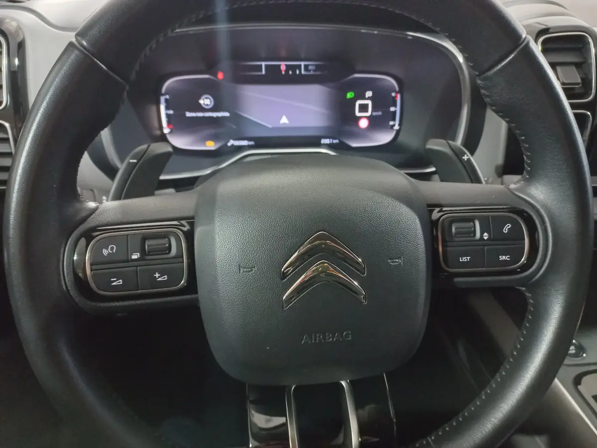 Gros plan sur le volant cuir noir du Citroën C5 Aircross 2020 avec commandes intégrées et tableau de bord numérique.