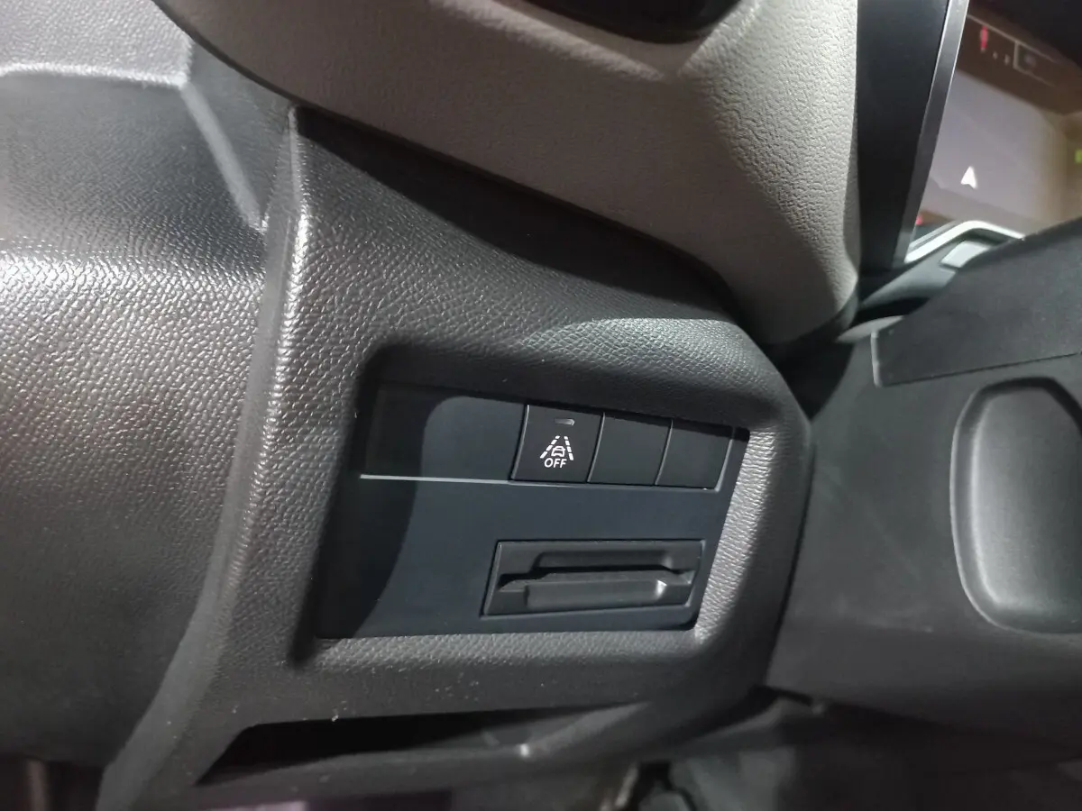 Gros plan sur le tableau de bord côté gauche du Citroën C5 Aircross blanc, bouton d'alerte franchissement de ligne visible.