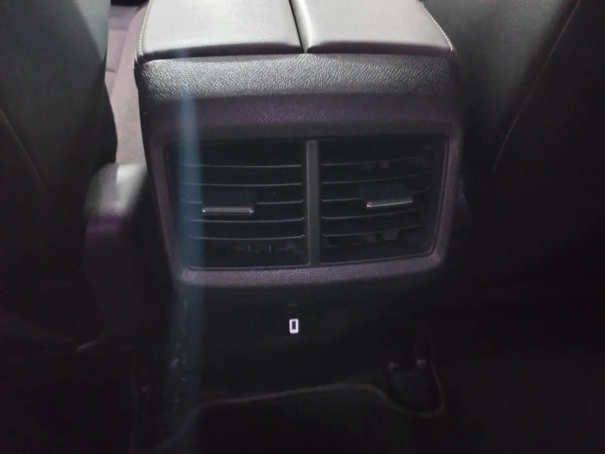 Bouche d'aération arrière noire vue de près entre les sièges arrière d'un Citroën C5 Aircross blanc de 2020